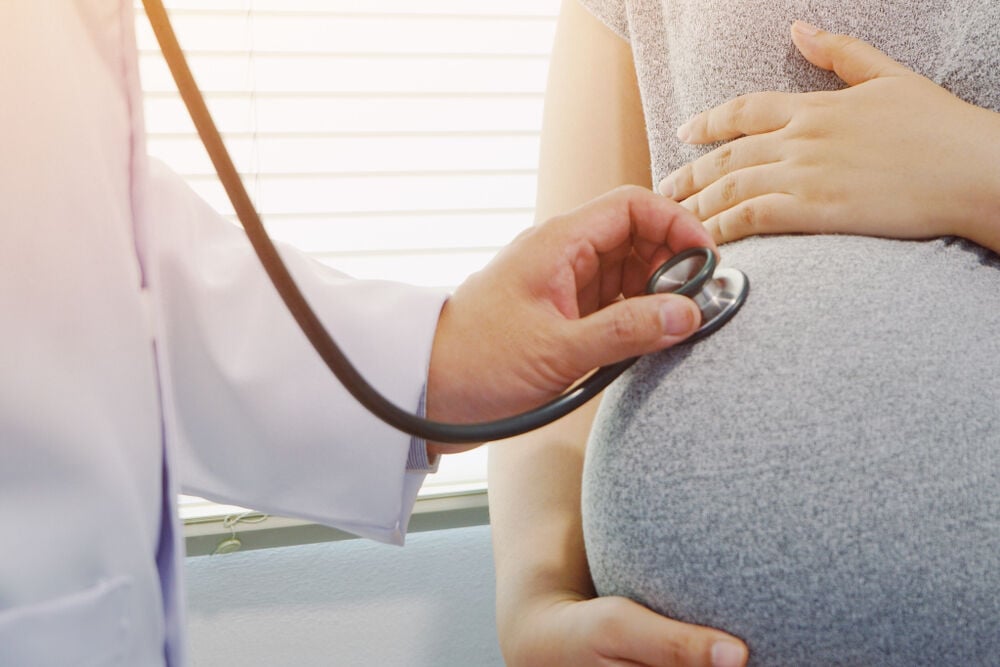 A doctor locating fetal heart sounds A doctor locating fetal heart sounds