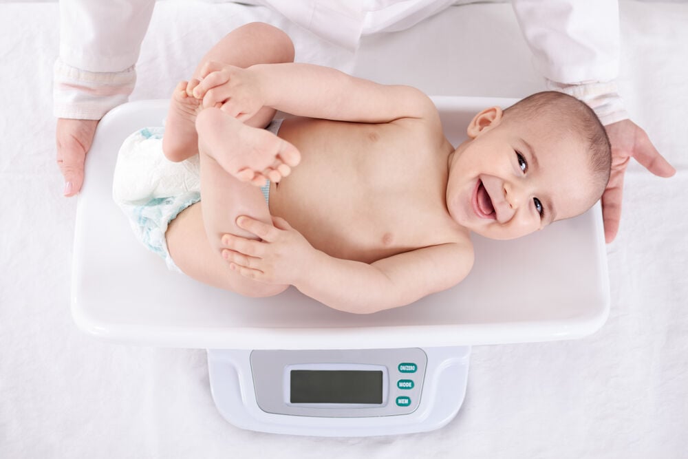 A doctor is measuring weight of a 9-month-old baby A doctor is measuring weight of a 9-month-old baby