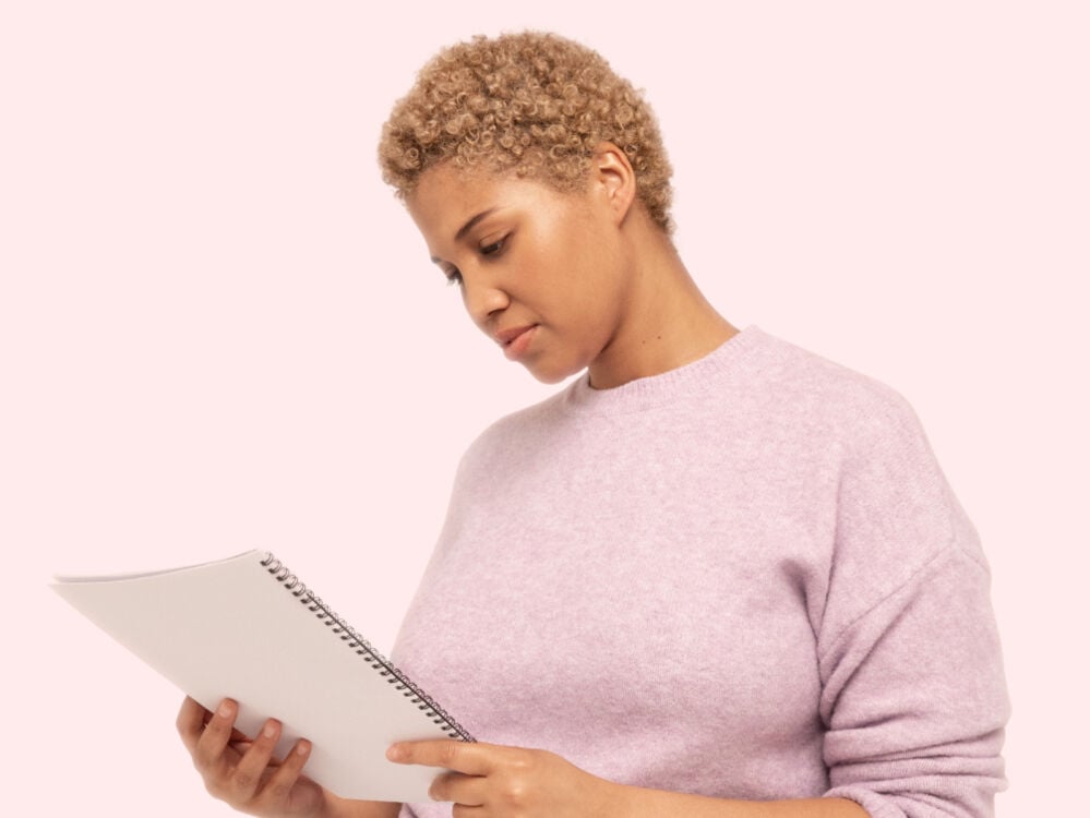 Perimenopausal woman reading a notepad Woman reading from notebook