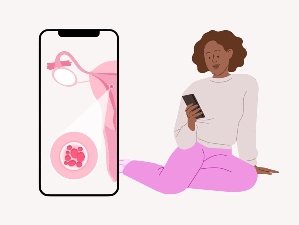 A woman reading about the signs and symptoms of implantation on her phone A woman reading about implantation on her phone