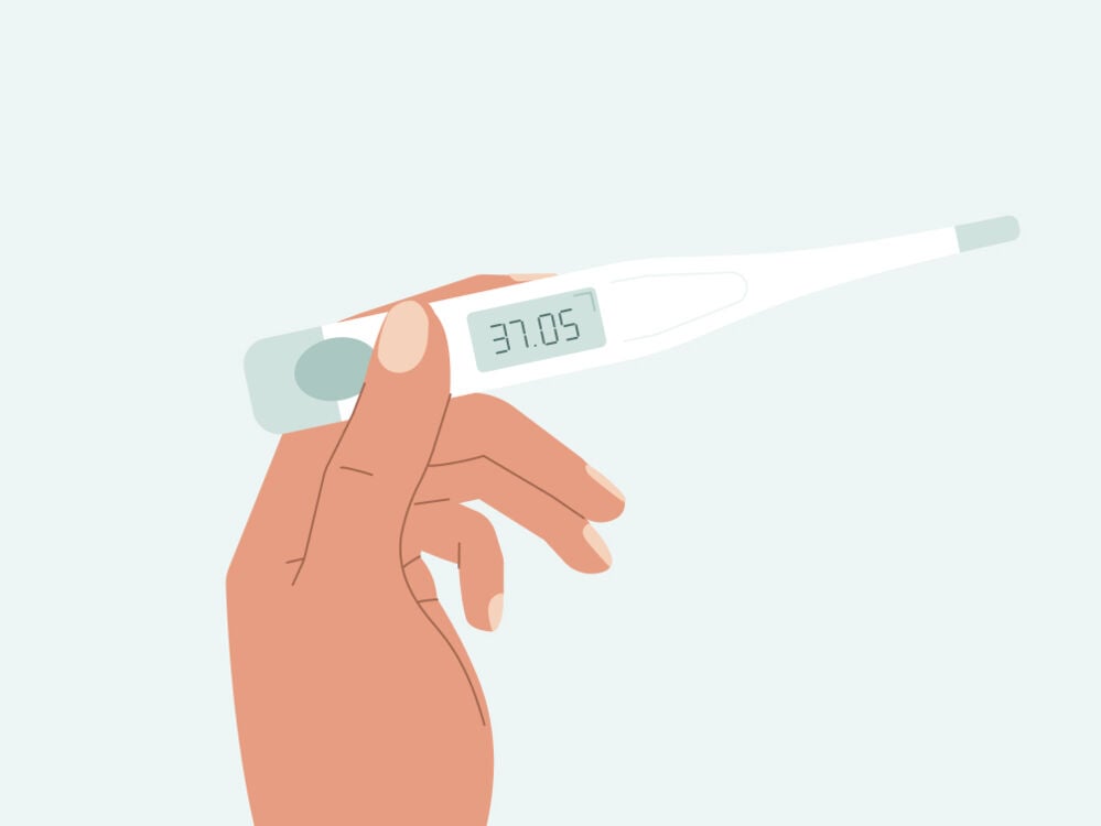 Hand holding a basal thermometer Basal thermometer