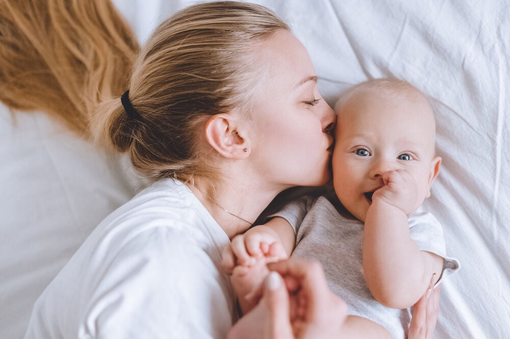 A woman trying to to soothe her teething infant A woman trying to to soothe her teething infant