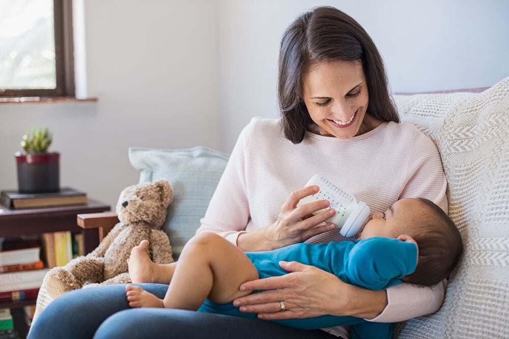 A woman feeding her baby before their nap A woman feeding her baby before their nap