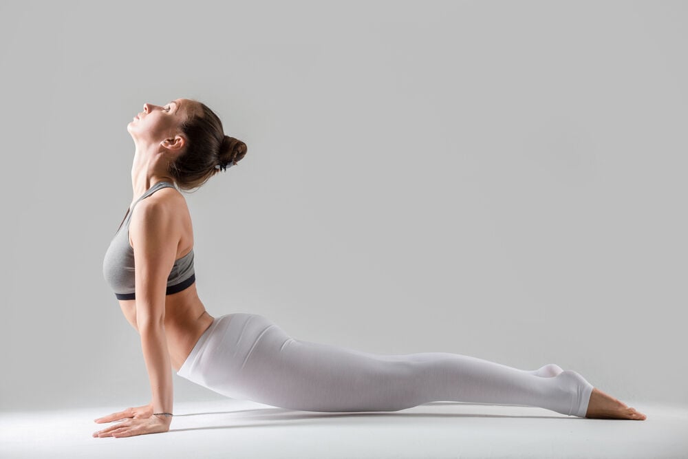 una mujer practicando yoga para prevenir el dolor de espalda baja una mujer practicando yoga para prevenir el dolor de espalda baja