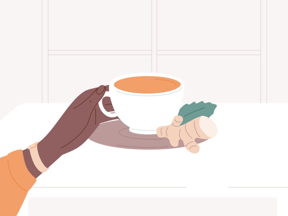hand holding a cup of ginger tea hand holding a cup of ginger tea