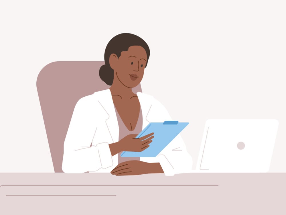 Doctor looking at chart while sat at her desk Doctor looking at chart while sat at her desk