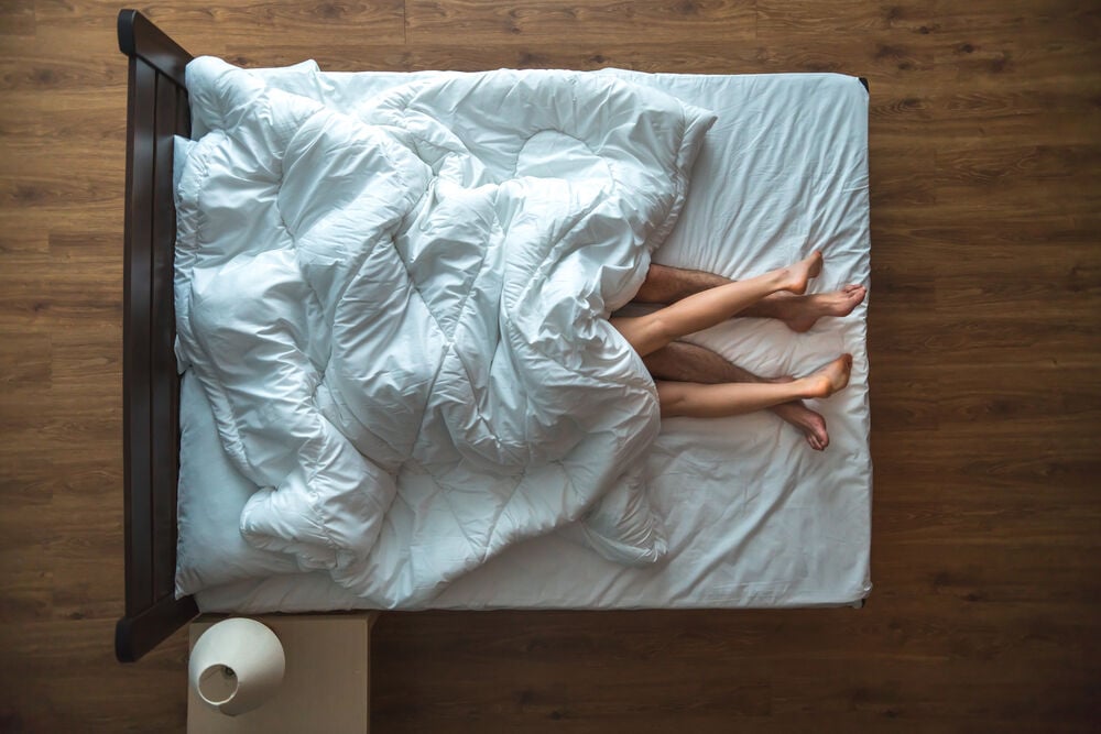 un hombre y una mujer en la cama con temor al sangrado vaginal un hombre y una mujer en la cama con temor al sangrado vaginal