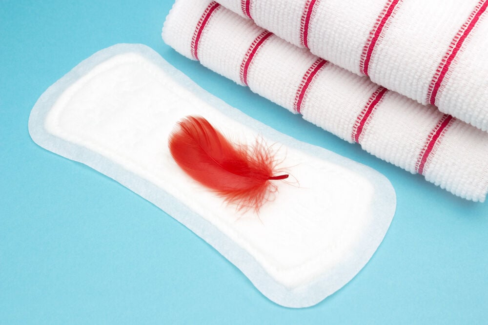 una compresa con una pluma roja encima una compresa con una pluma roja encima