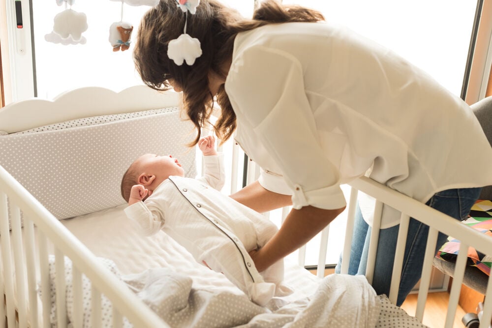 A woman putting her baby down A woman putting her baby down