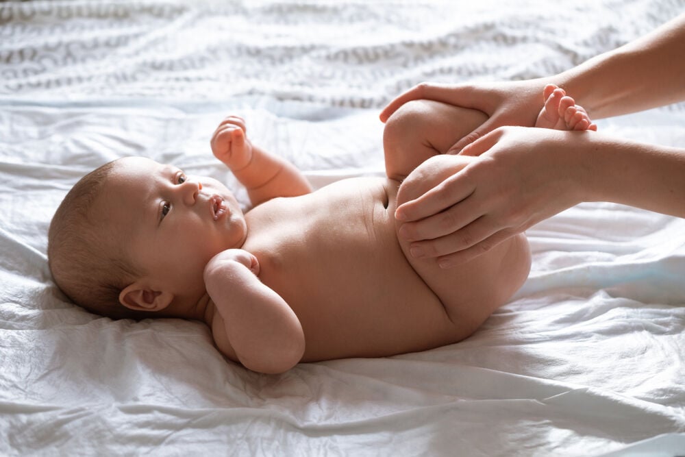 Tucking baby's knees into their stomach is an effective baby gas relief method Tucking baby's knees into their stomach is an effective baby gas relief method