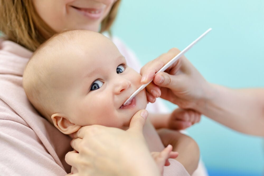 A doctor examines baby's teeth that are coming in crooked A doctor examines baby's teeth that are coming in crooked