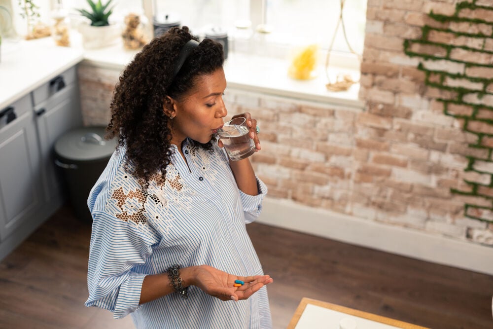 A woman takes vitamins to support her baby’s brain development A woman takes vitamins to support her baby’s brain development