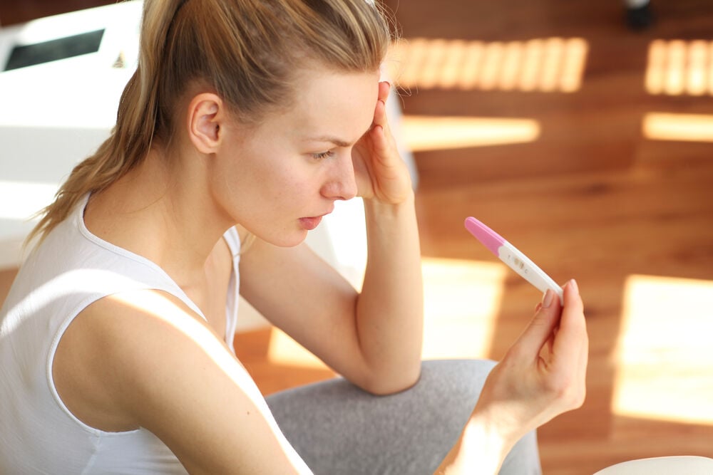 A woman having a stealth pregnancy looking at a negative test result A woman having a stealth pregnancy looking at a negative test result