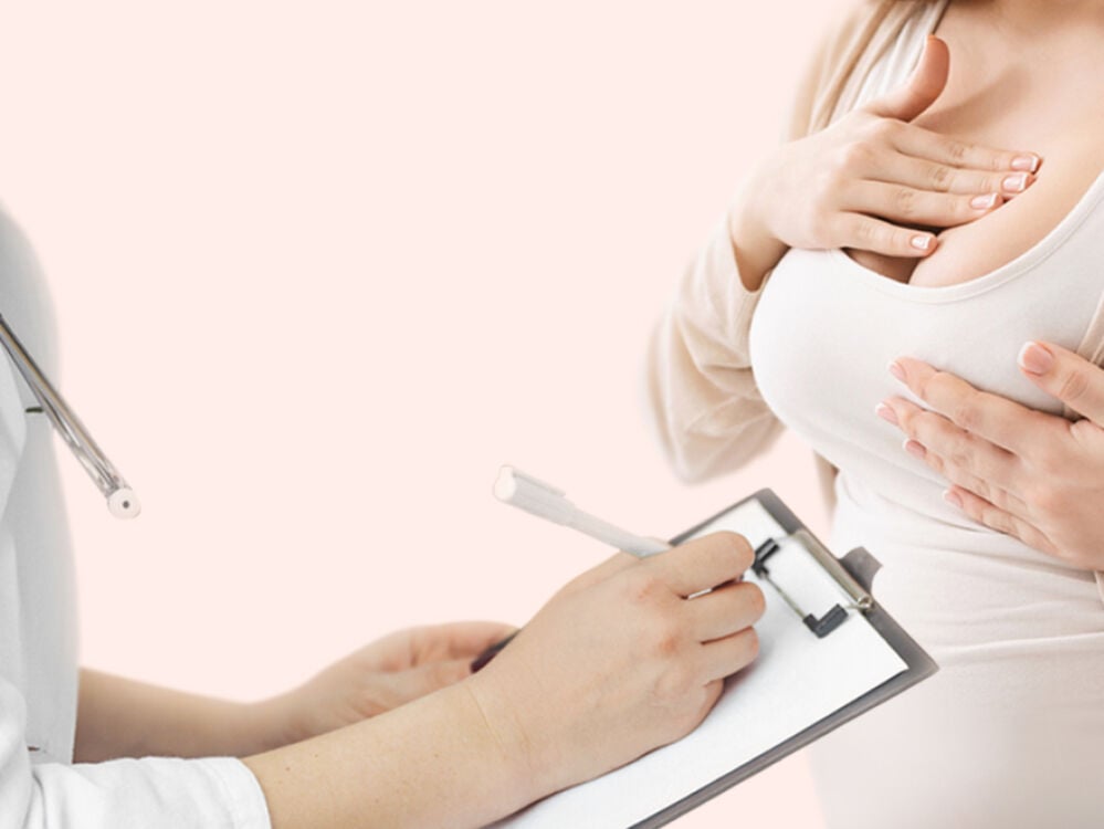 woman at doctors holding her sore breasts woman at doctors holding her sore breasts