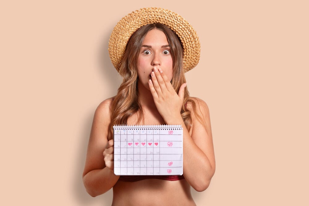 A woman calculating her cycle and wearing period swimwear A woman calculating her cycle and wearing period swimwear
