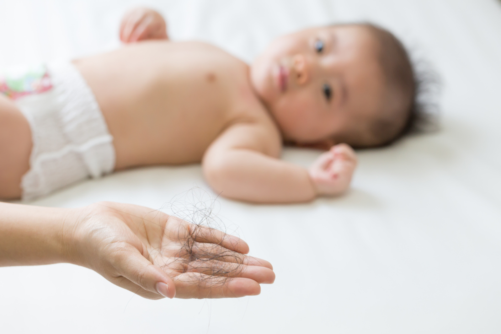 hair in the hand and a baby postpartum hair in the hand and a baby postpartum
