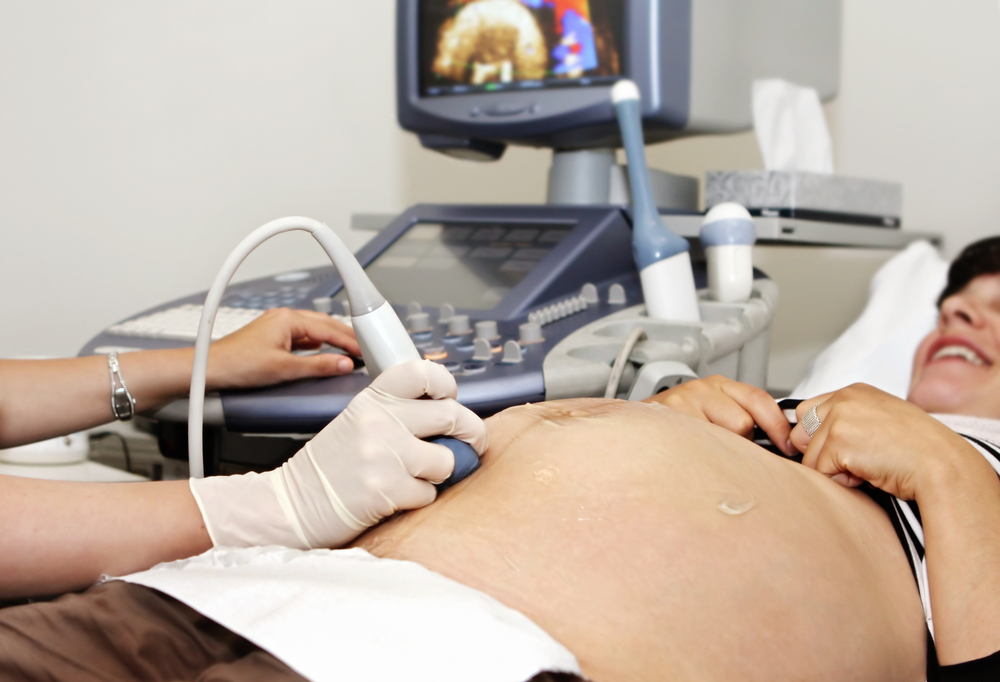 pregnant woman receives an ultrasound. 34 weeks gestation. pregnant woman receives an ultrasound. 34 weeks gestation.