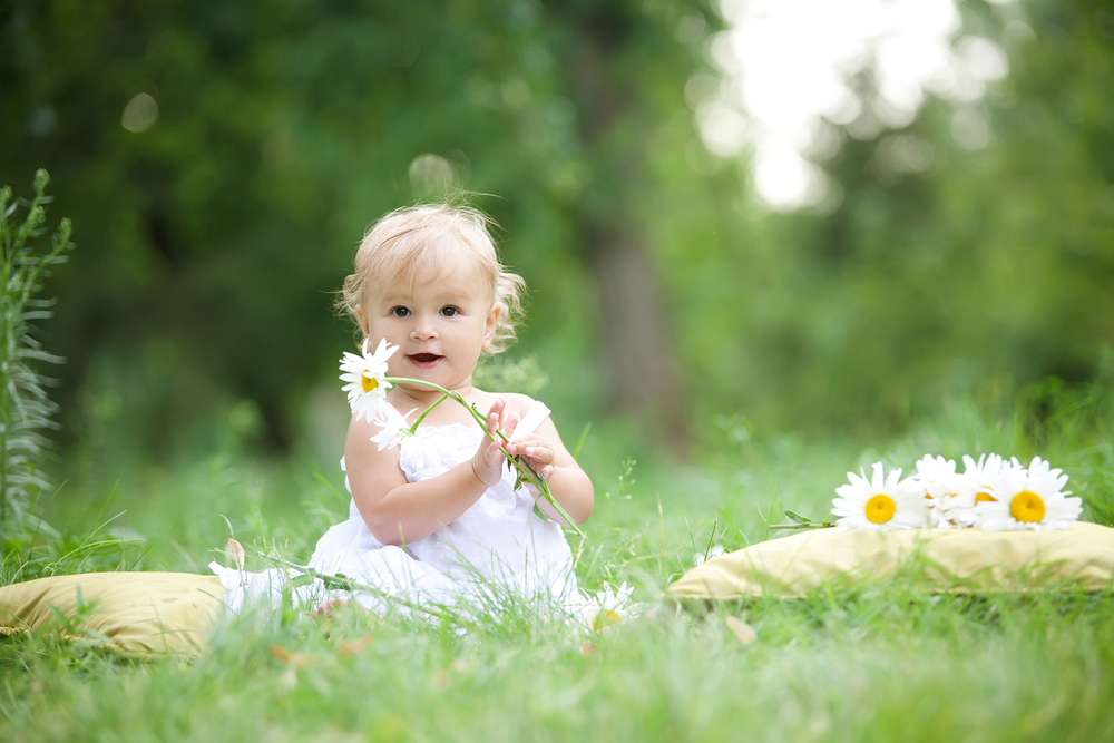 A toddler with camomiles as a symbol of flower girl names