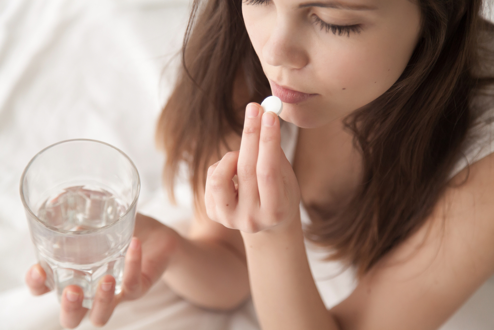 A girl taking pills as a form of medical abortion A girl taking pills as a form of medical abortion