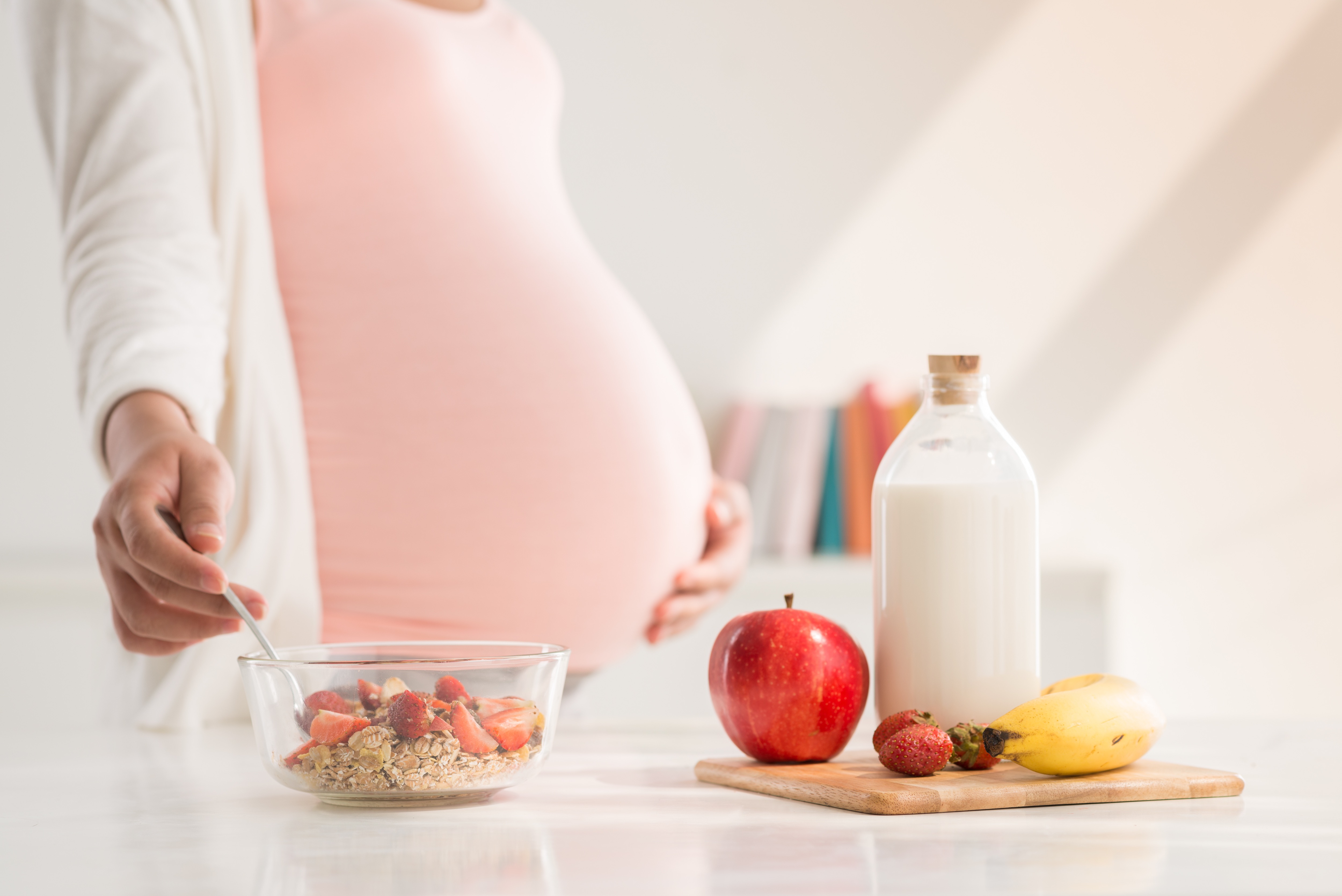 Pregnant woman preparing meal with milk and fruits Pregnant woman preparing meal with milk and fruits