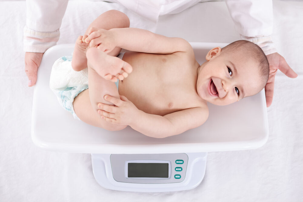 A doctor is measuring weight of a 9-month-old baby