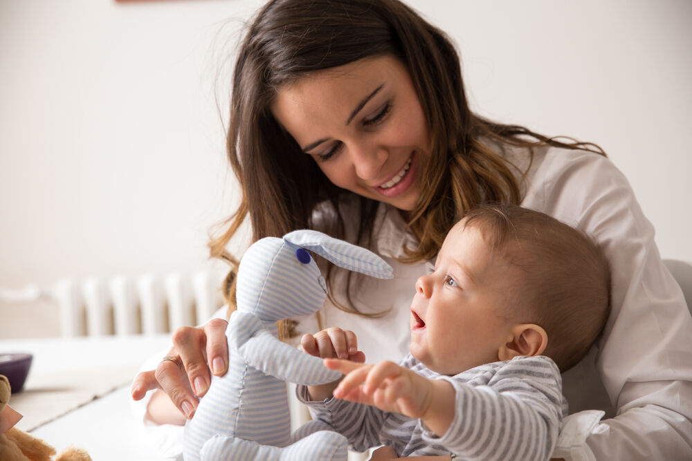 A woman nurturing baby’s development by introducing different toys at playtime