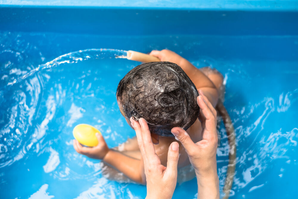 A mom washes baby's hair to get rid of baby's dry scalp