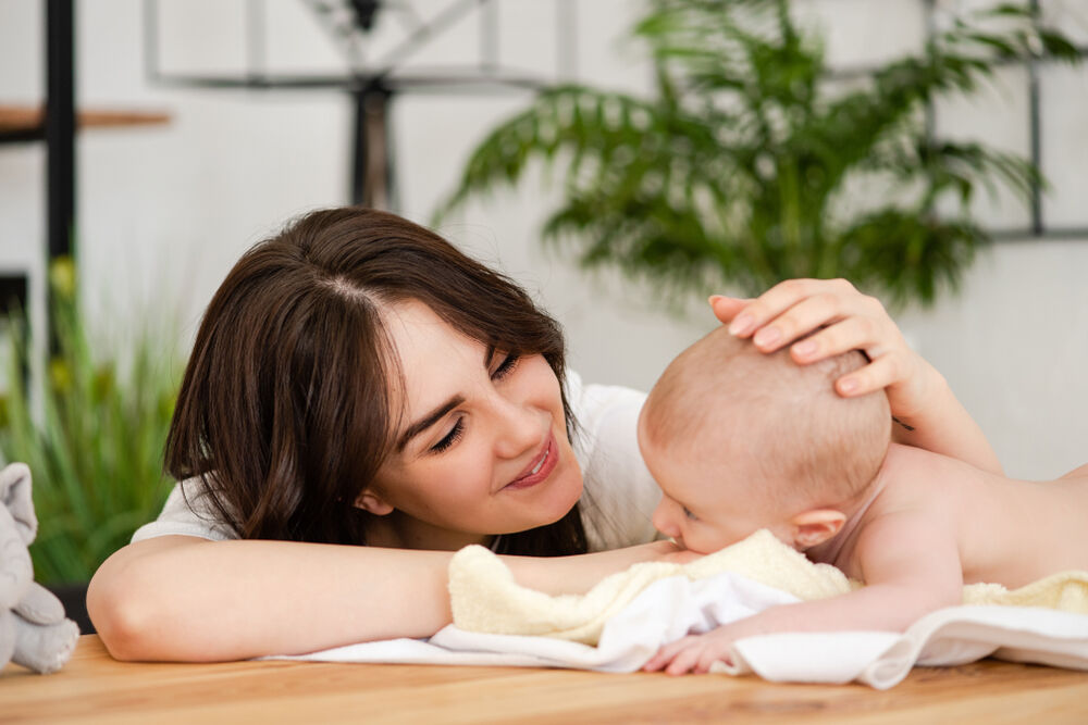 A mom gently massages baby's scalp to get rid of baby's dry scalp