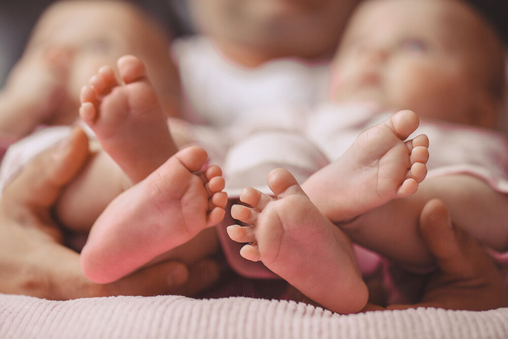 Paternal twins' feet in mother's hands