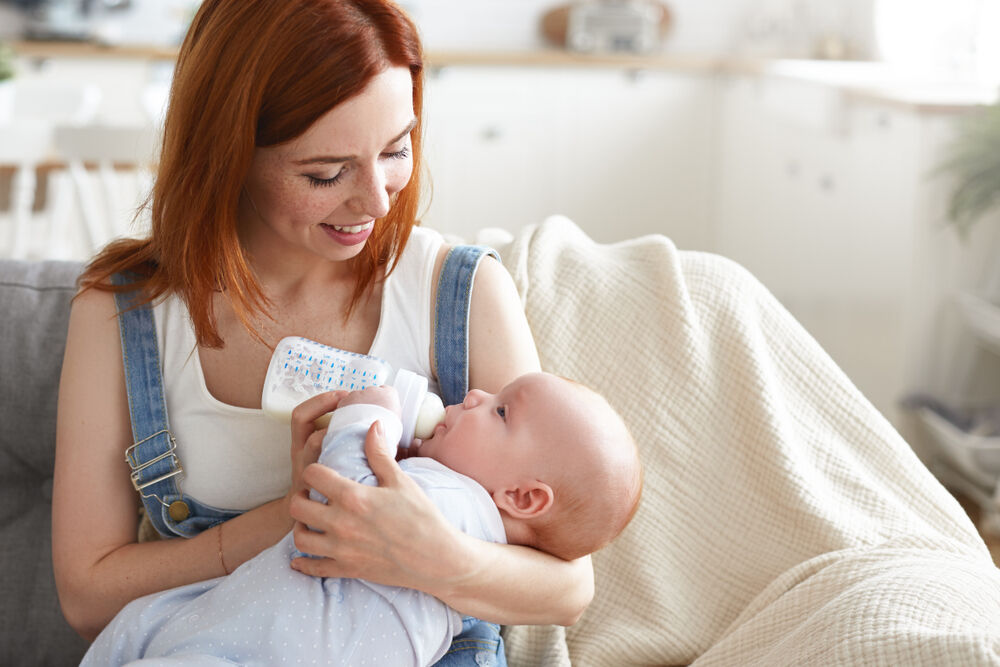 A mother feeding her baby hand expressed breast milk