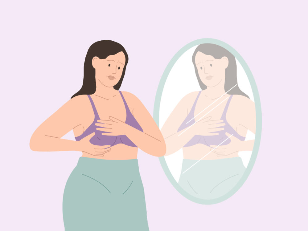 woman looking at and feeling her breasts in the mirror