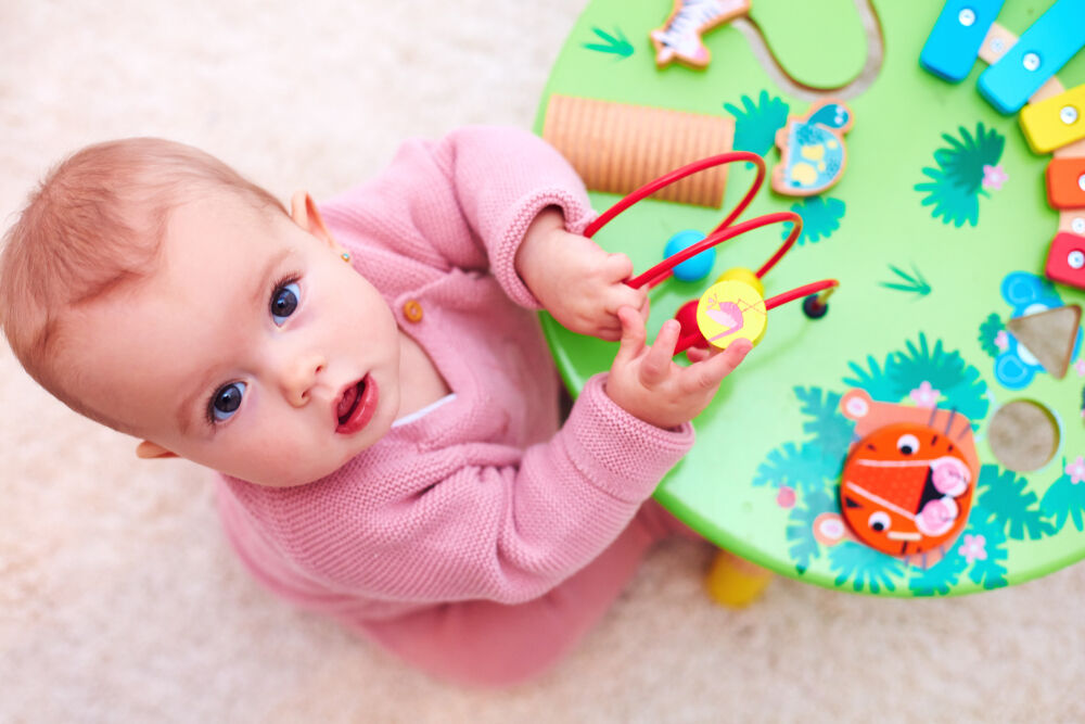A baby is playing with a learning toy for 6-month-old babies