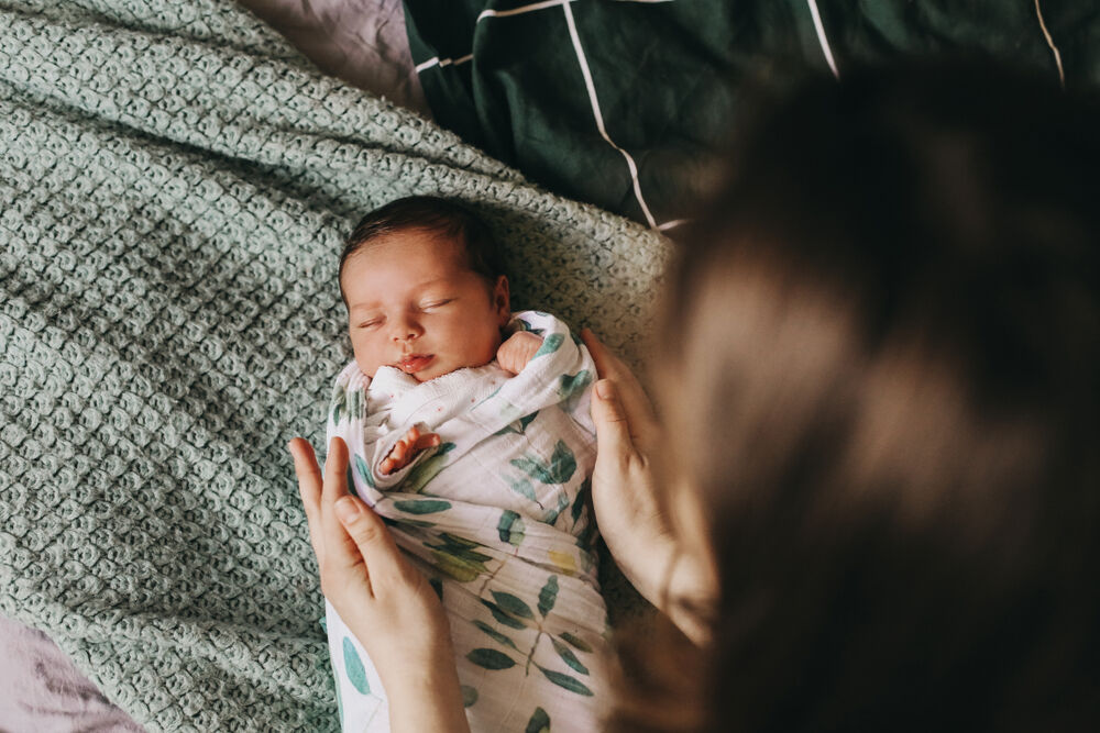 A mother swaddling a baby