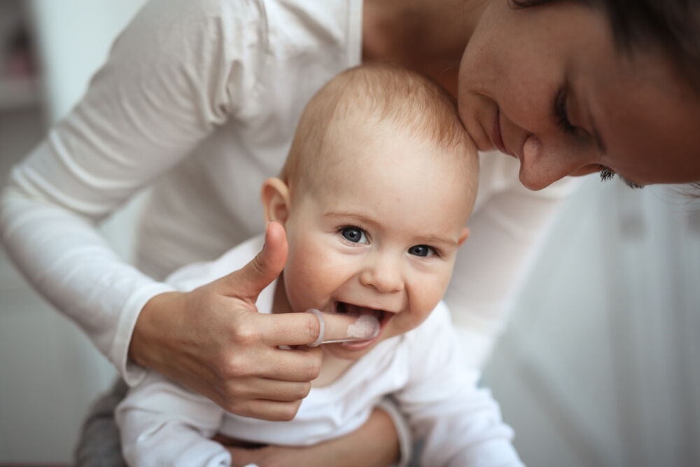A mom placing antifungal gel on her baby’s tongue to get rid of oral thrush