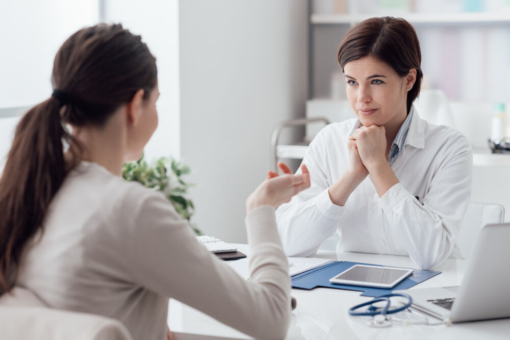 un médico en consulta escuchando a una paciente