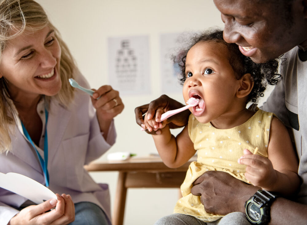 A doctor showing how to remove stains from baby teeth