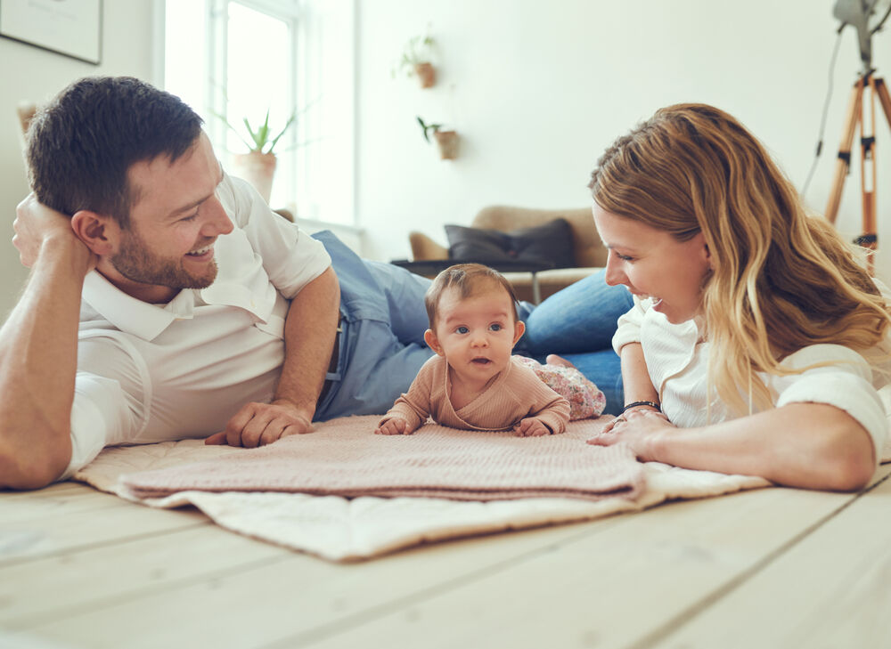 Young parents learning how to do tummy time with a newborn