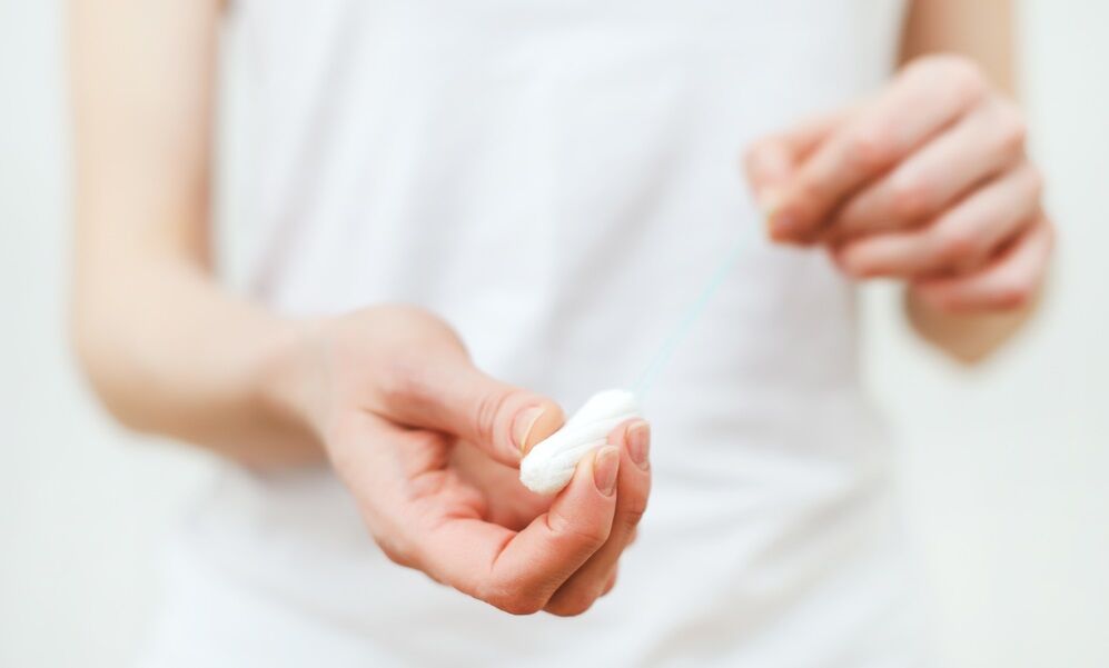 A woman is getting ready to insert a tampon without an applicator