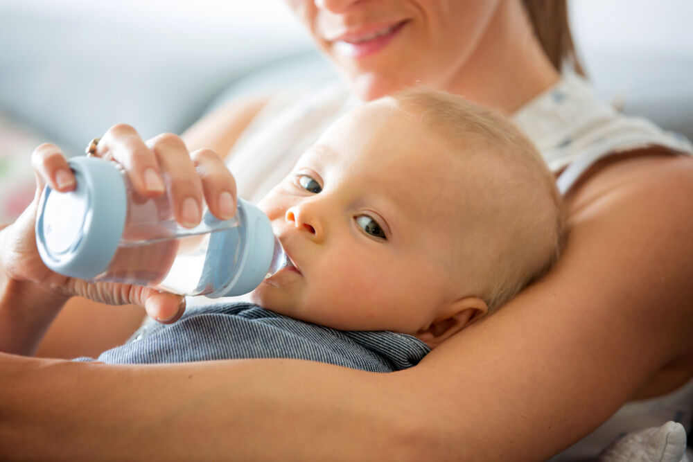 A baby gets accustomed to drinking water