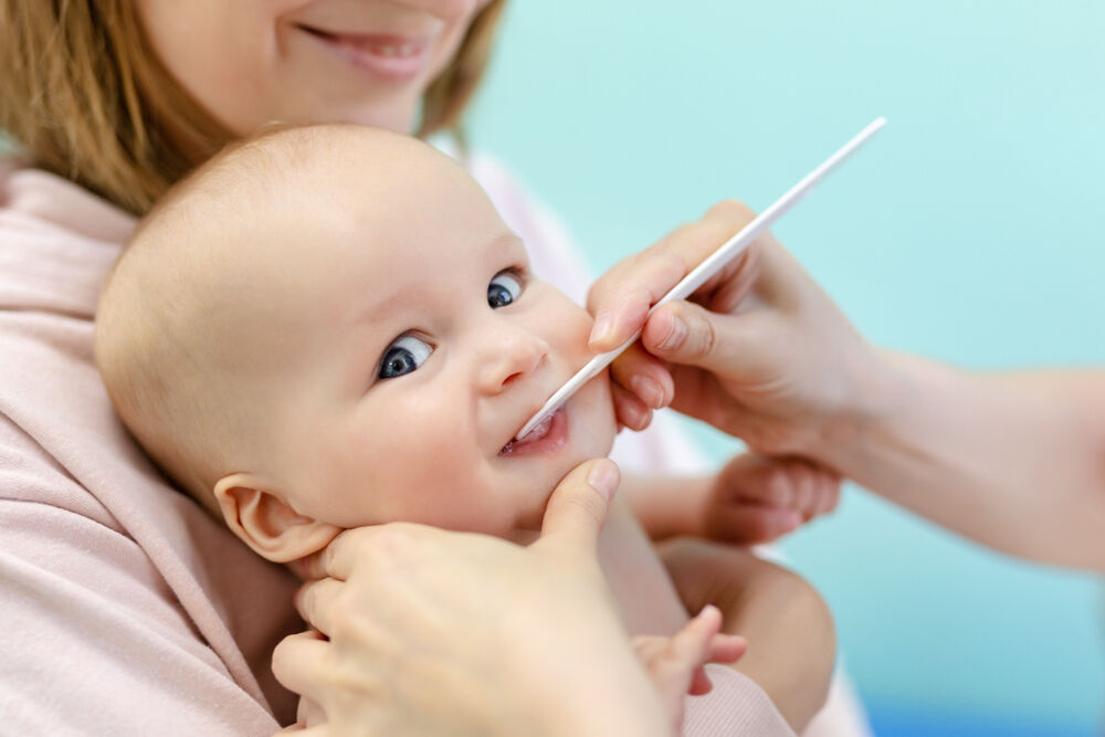 A doctor examines baby's teeth that are coming in crooked