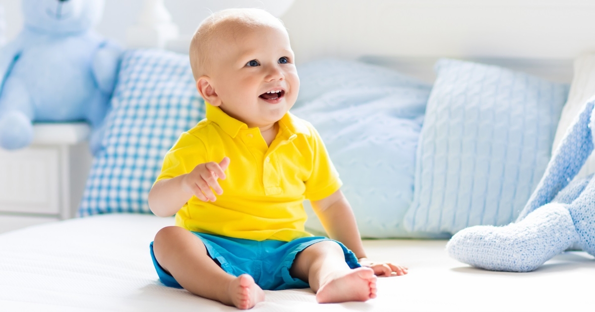 Full Length Of Baby Sitting Isolated On White Background Stock Photo