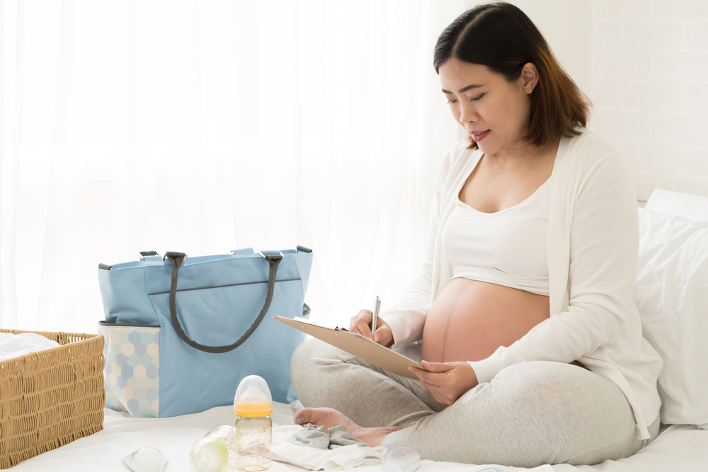 A pregnant woman prepares a checklist of things to take to the delivery center
