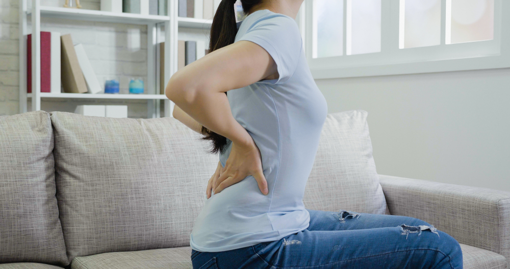 woman experiencing a mild backache woman experiencing a mild backache