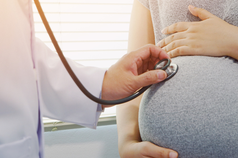 A doctor locating fetal heart sounds A doctor locating fetal heart sounds
