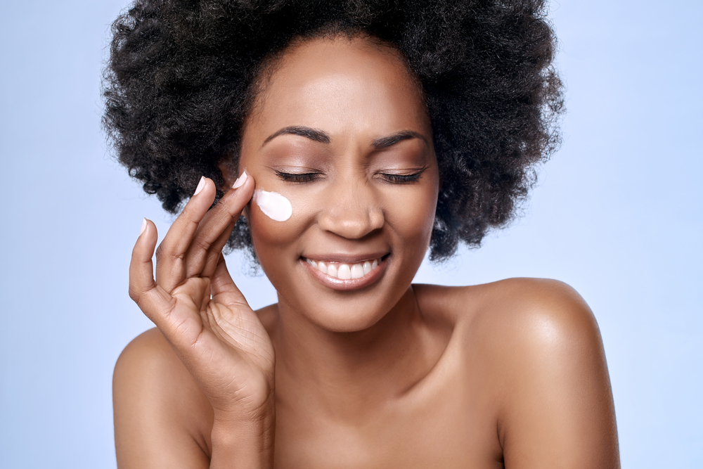 A woman applying anti-aging moisturiser face cream A woman applying anti-aging moisturiser face cream