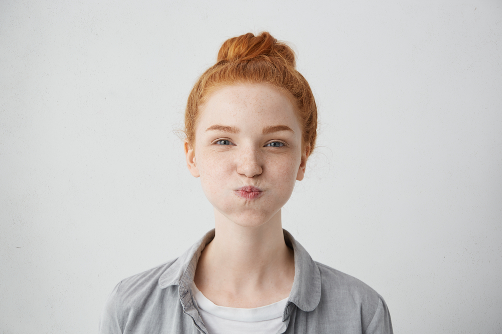 A girl bloating her cheeks as a symbol of ovulation bloating A girl bloating her cheeks as a symbol of ovulation bloating