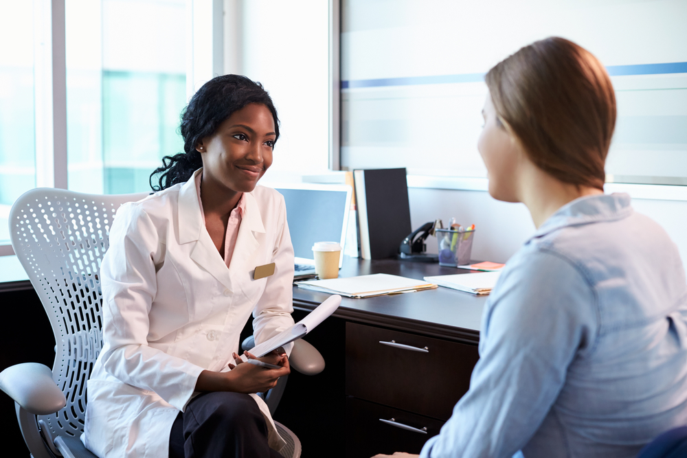 Doctor Consultation With Female Patient In Office