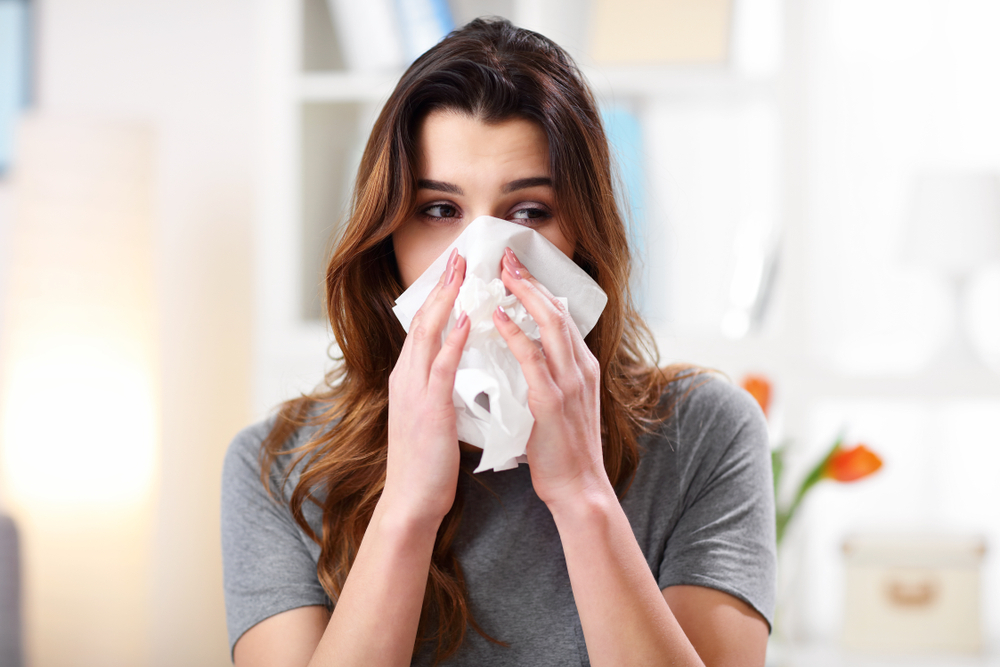 Woman sneezing with her eyes open Woman sneezing with her eyes open