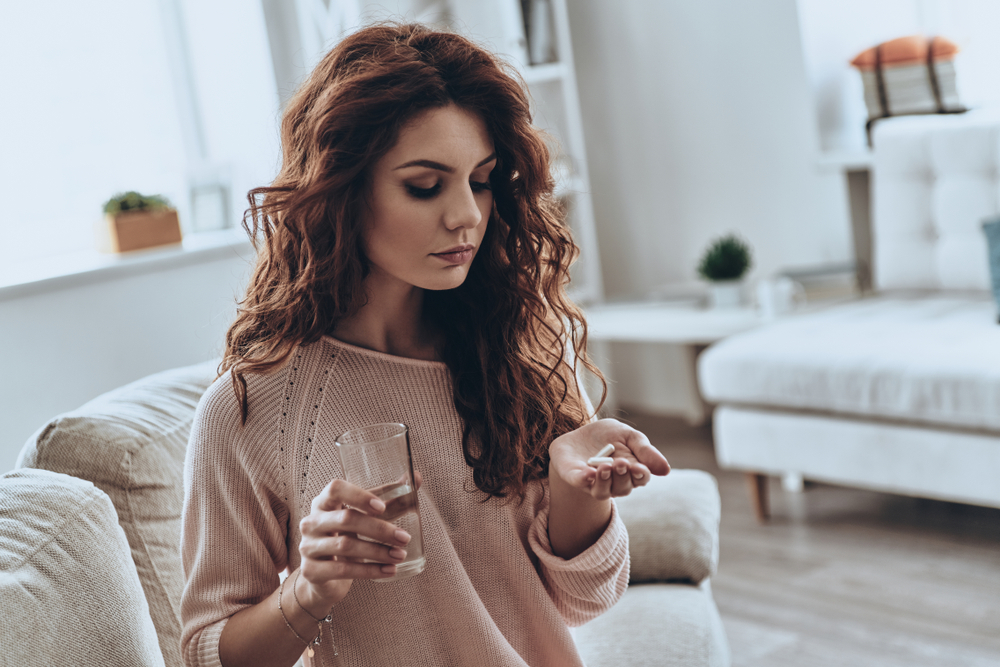woman taking her emergency contraception birth pill woman taking her emergency contraception birth pill