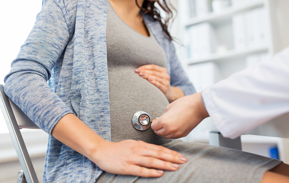 gynecologist doctor with stethoscope listening to pregnant woman gynecologist doctor with stethoscope listening to pregnant woman